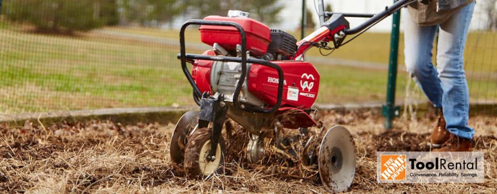 Home Depot tool rental. person using a tiller from Home Depot rentals to create a garden,