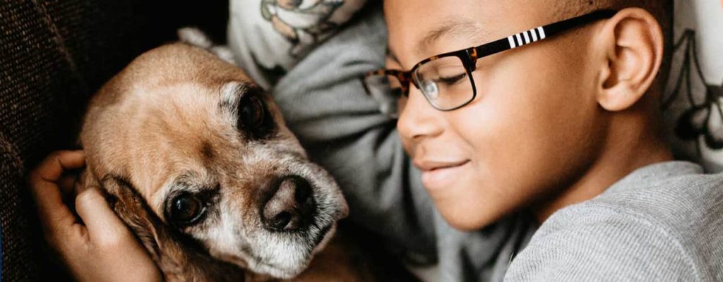 Little boy cuddling with his old sweet dog